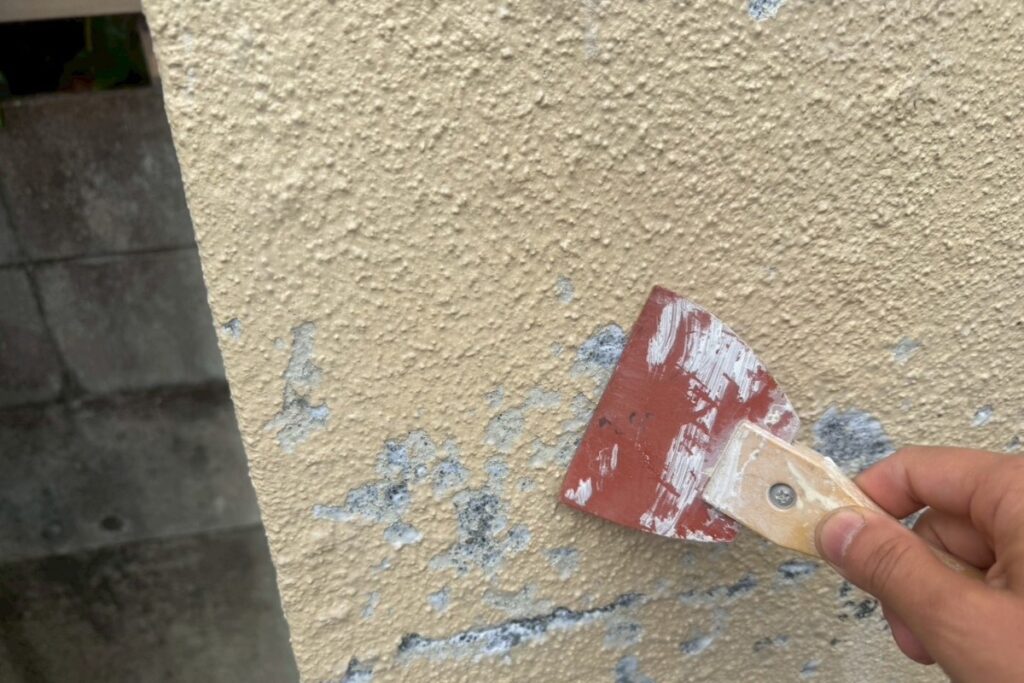 擁壁の凹凸や塗膜剥がれ部分を補修する下地処理作業