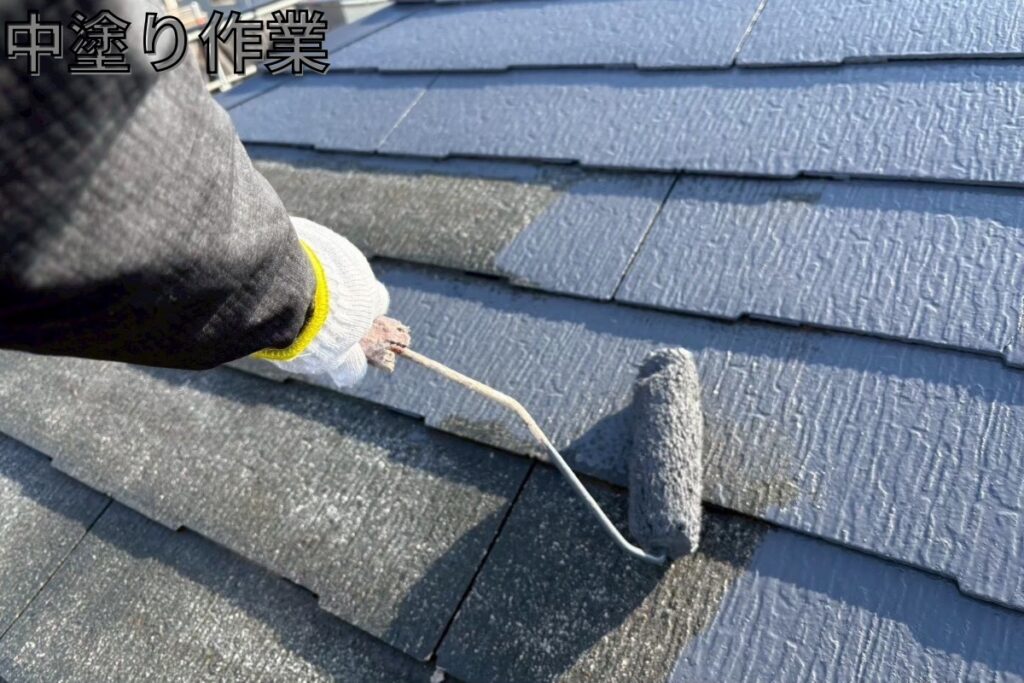 仙台市太白区の屋根塗装でスレート屋根を中塗りしている様子