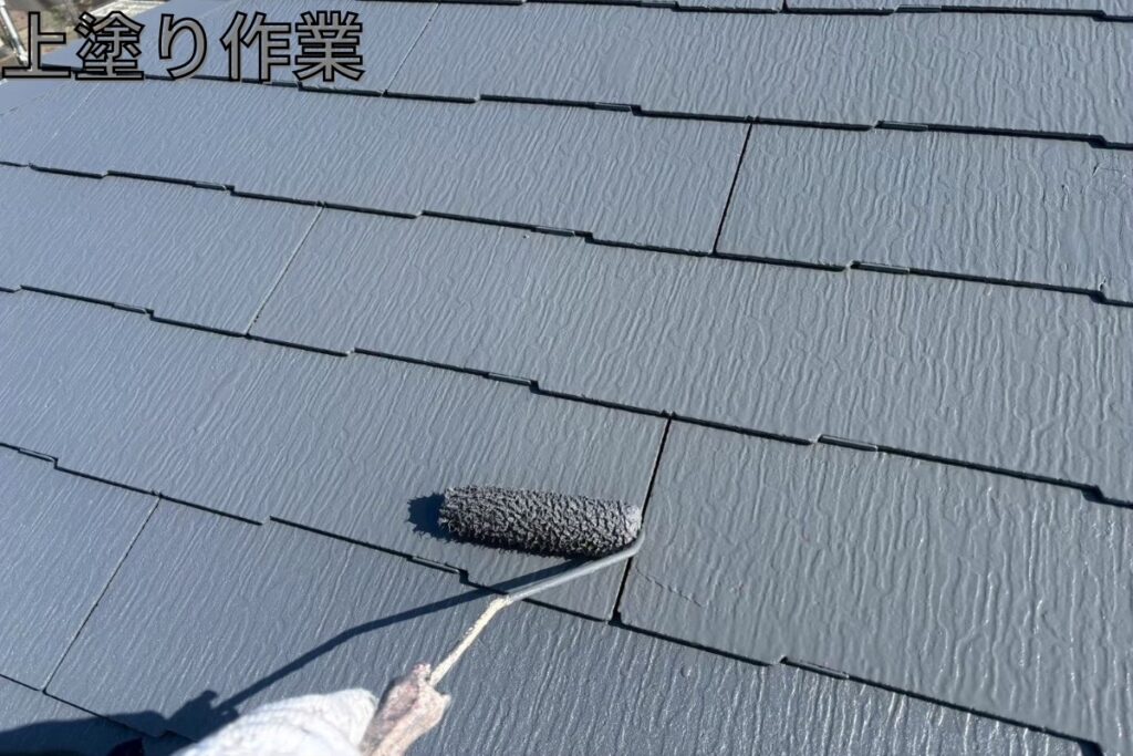仙台市太白区のスレート屋根塗装で上塗り仕上げをしている様子